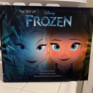 Disney Frozen Art Book with Blue and Black Cover autographed by team.